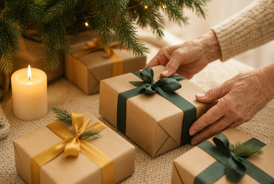 Weihnachtsgeschenke in Kraftpapier mit grünen und goldenen Bändern unter Tannenzweigen