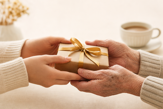 Kleines Geschenk mit Goldband wird an ältere Hände übergeben