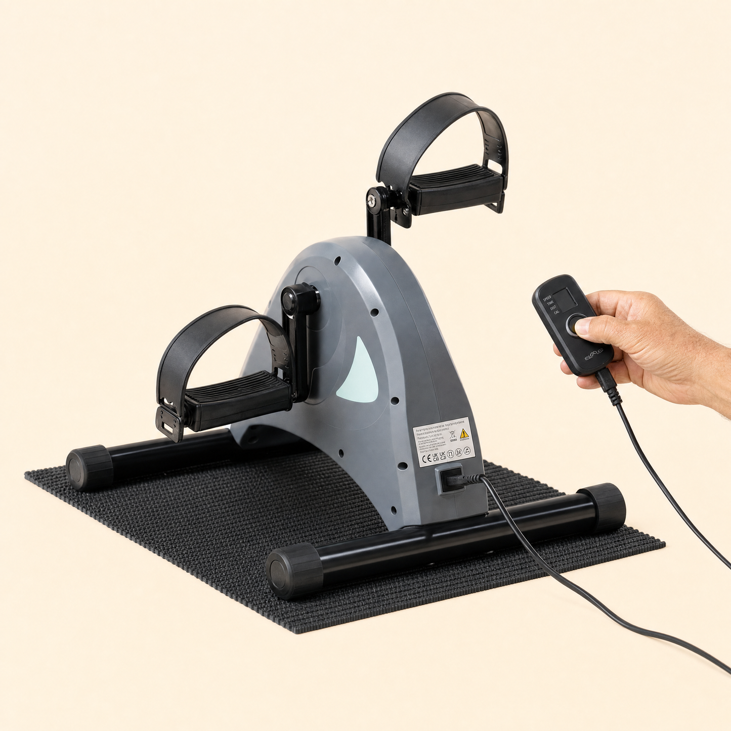 Pedaltrainer mit Fernbedienung in der Hand